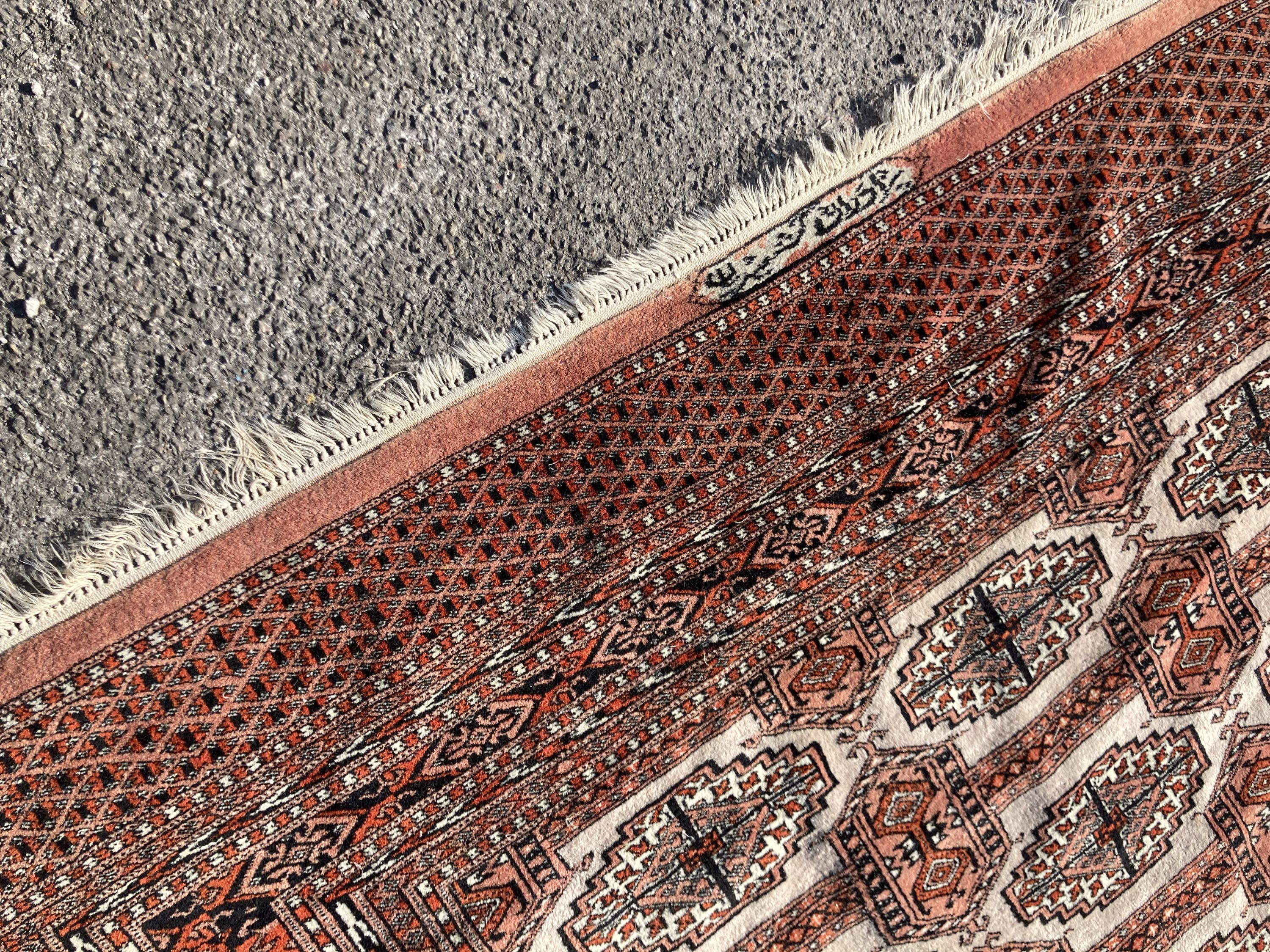 A pale red ground Tekke rug with signed border, 260 x 162cm